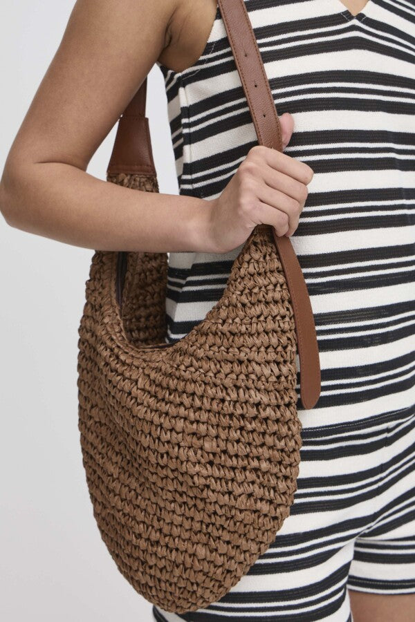 ICHI - Cathe Shoulder Bag
handbag, bag, beach bag, casual bag, casual handbag, shoulder bag, shoulder handbag, shoulder beach bag, small casual bag, small casual handbag, ichi, paper, raffia, paper bag, paper handbag, paper bag, raffia handbag, raffia beach bag

image shows a model wearing the brown crochet paper bag over her shoulder. she is resting her hand on the leather belt looking strap