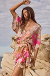 Woman in a floral dress standing on rocky terrain with a cloudy sky.
Floridian Lace Mini Dress