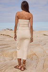 Woman in a strapless white dress standing on a sandy beach with a clear sky.
Playa Midi Dress