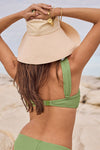 Woman wearing a green bikini and beige sun hat on a beach
\Playa Bandeau