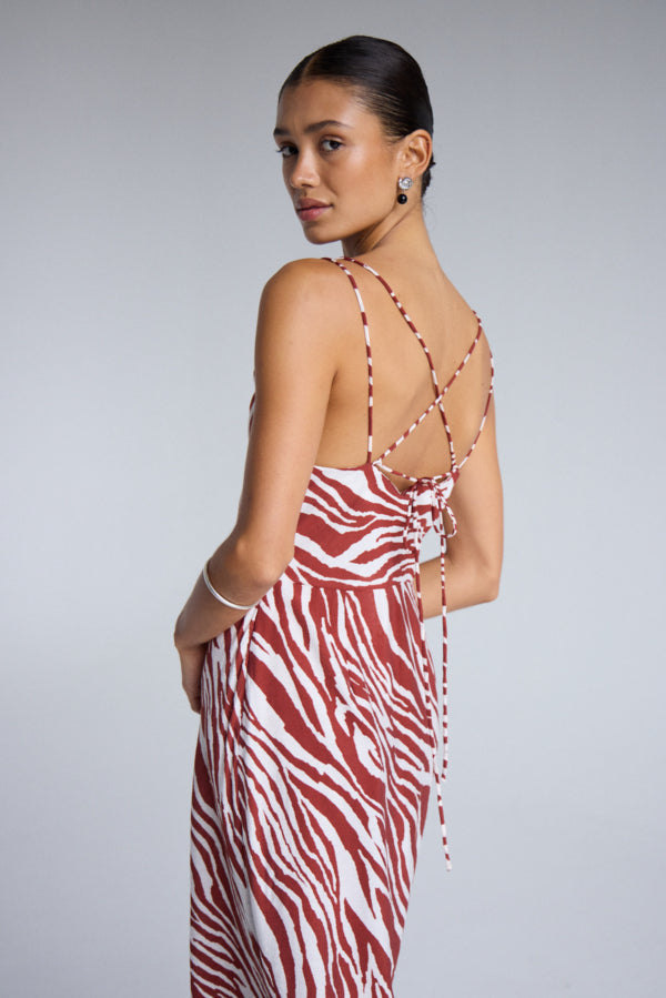 ICHI - Yardeen Dress
dress, long dress, maxi dress, midi dress, zebra print, zebra print dress, strappy dress, summer dress, spring dress, resort wear, holiday wear, resort dress

image shows model wearing a long dress with a rust coloured zebra print. it has a strappy open back and she is looking over her shoulder at the camera