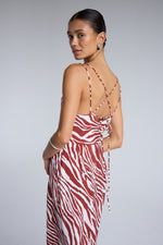 ICHI - Yardeen Dress
dress, long dress, maxi dress, midi dress, zebra print, zebra print dress, strappy dress, summer dress, spring dress, resort wear, holiday wear, resort dress

image shows model wearing a long dress with a rust coloured zebra print. it has a strappy open back and she is looking over her shoulder at the camera