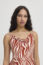 ICHI - Yardeen Dress
dress, long dress, maxi dress, midi dress, zebra print, zebra print dress, strappy dress, summer dress, spring dress, resort wear, holiday wear, resort dress

image shows model corm the waist up. she is wearing a rust coloured zebra print dress with a cowl neck and thin straps. the waist is quite high and the model is looking into the camera. 