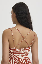 ICHI - Yardeen Dress
dress, long dress, maxi dress, midi dress, zebra print, zebra print dress, strappy dress, summer dress, spring dress, resort wear, holiday wear, resort dress

image shows model from the waist up. she is wearing a rust coloured zebra print dress with a strappy but open back. the straps tie in the back, and the waist is quite high. the model is looking away from the camera. 