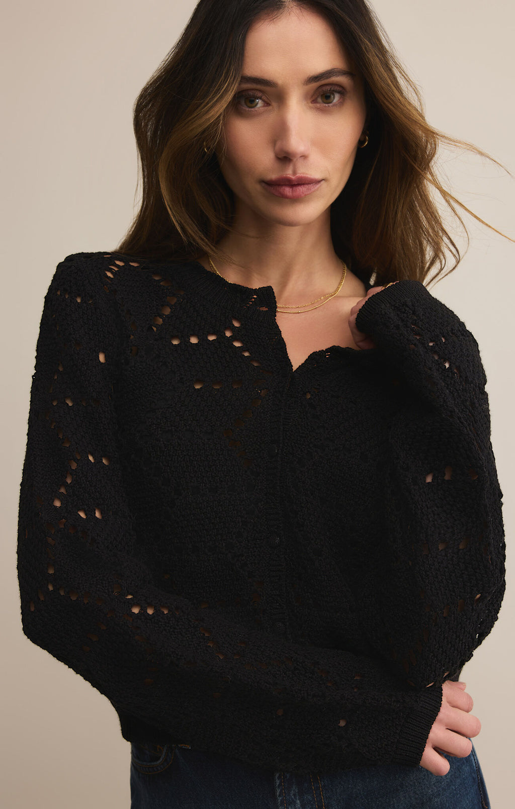 Woman wearing a black long-sleeve shirt and blue jeans on a beige background
Rosalyn Sweater