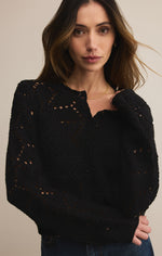 Woman wearing a black sweater with cut-out details on a beige background
Rosalyn Sweater