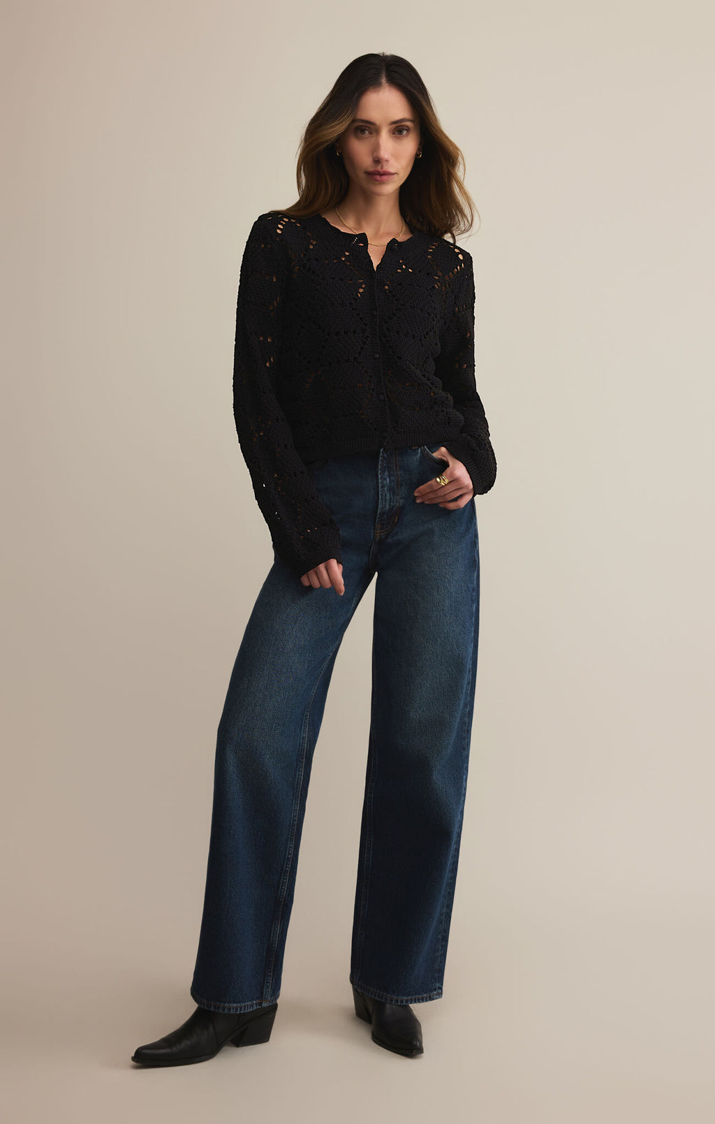 Woman wearing a black long-sleeve shirt and blue jeans on a beige background
Rosalyn Sweater