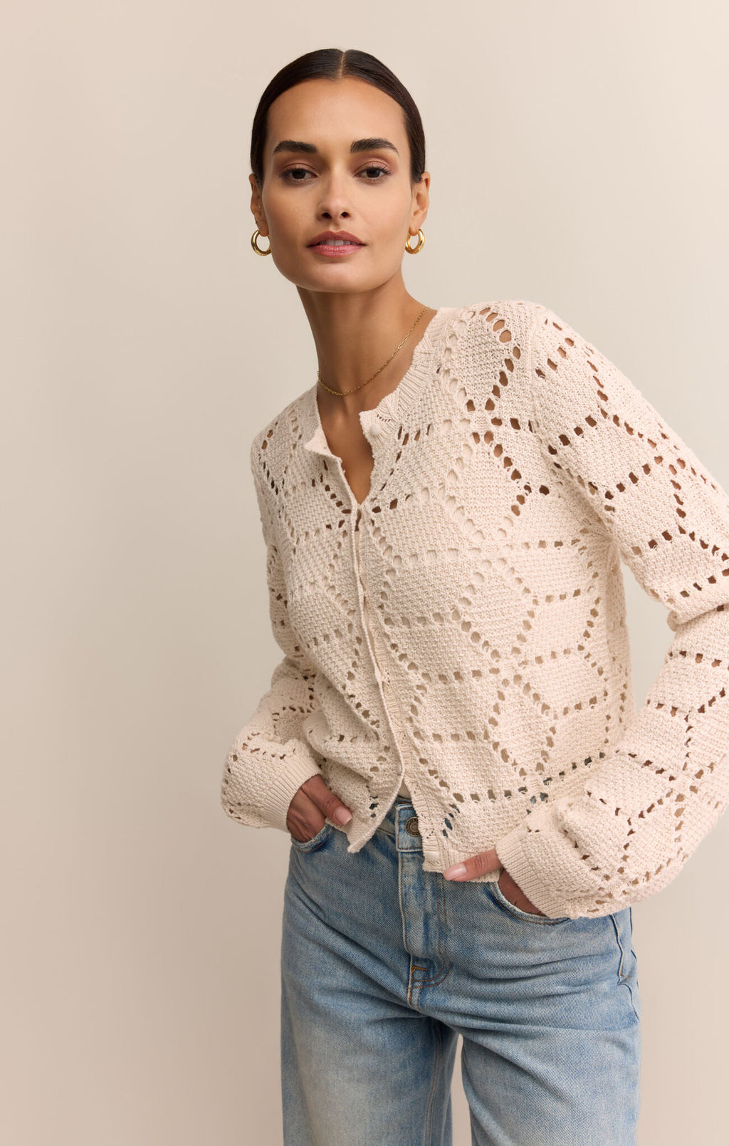 Woman wearing a white lace top and blue jeans on a beige background
Rosalyn Cardigan Sweater