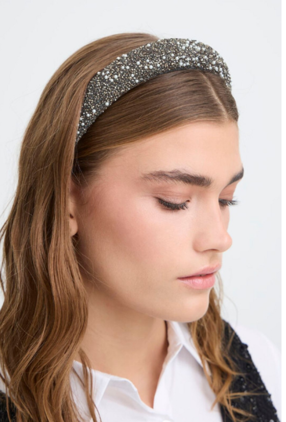 Woman wearing a sparkling headband against a white background